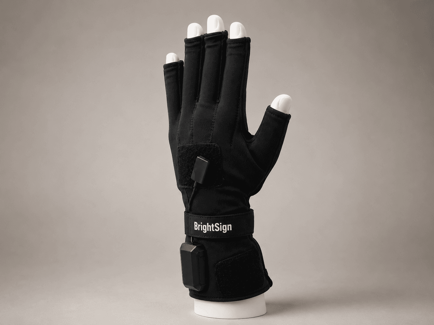Black glove with electronic components on a mannequin hand, labeled "BrightSign," against a gray background.
